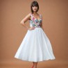 White mi-long sleeveless floral dress with square neckline.